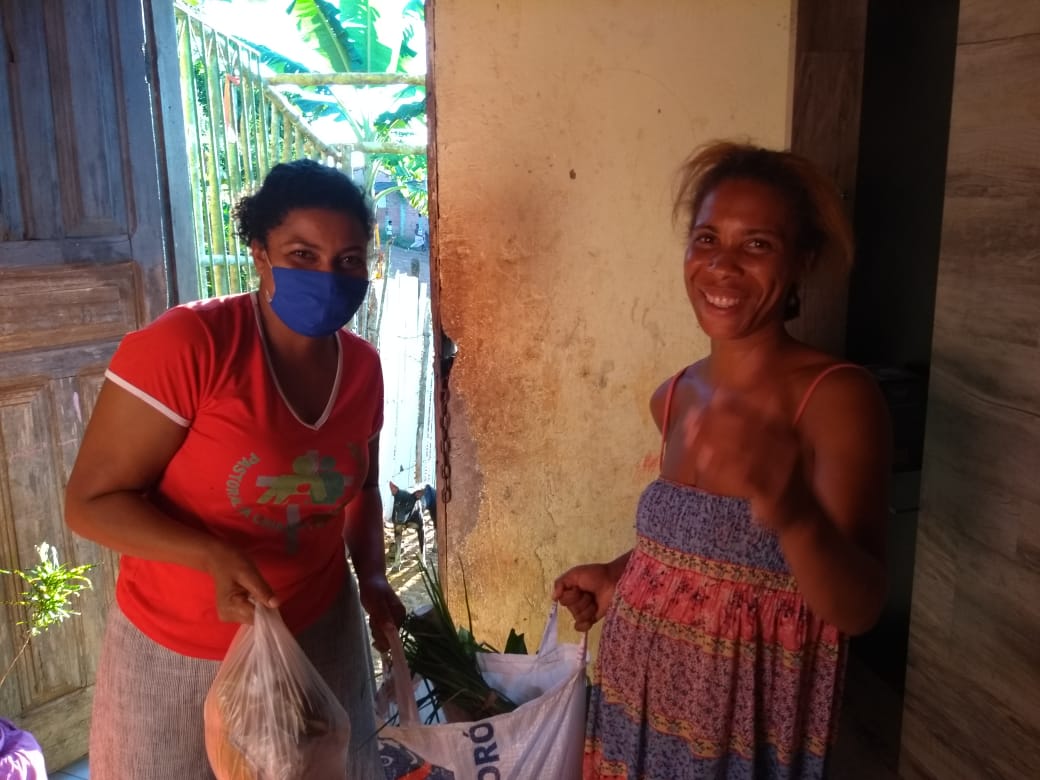 Mulheres negras entregando alimentos uma a outra Mulheres negras entregando alimentos uma a outra