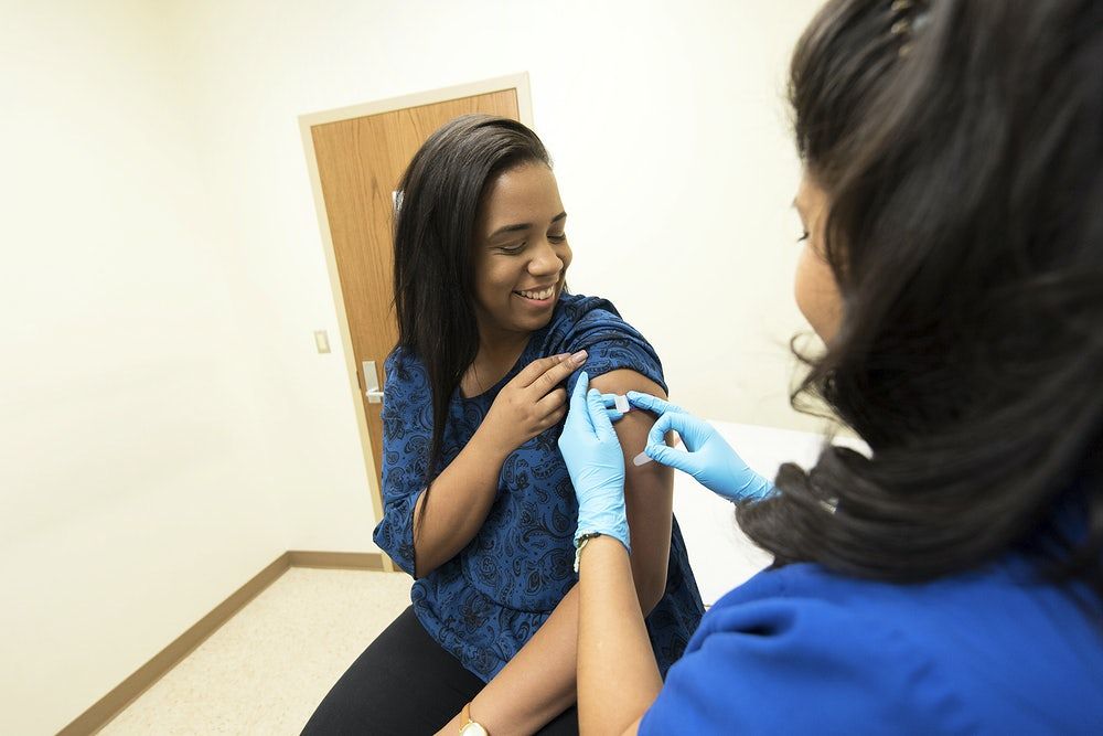 Mulher toma primeira dose da vacina Mulher toma primeira dose da vacina