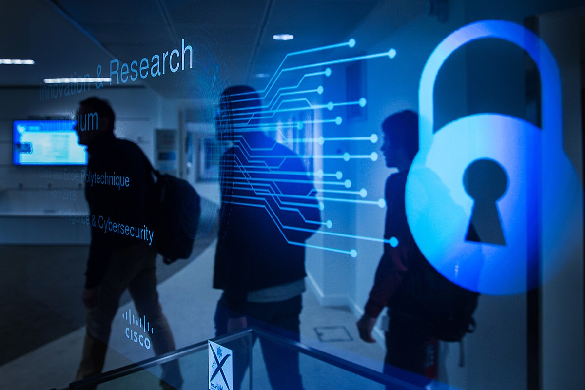 Imagem com o texto "Research" (pesquisa, em língua inglesa) em uma tela em primeiro plao junto com ramificações de códigos e um cadeado. Ao fundo, uma silhueta caminha. Imagem com o texto "Research" (pesquisa, em língua inglesa) em uma tela em primeiro plao junto com ramificações de códigos e um cadeado. Ao fundo, uma silhueta caminha.