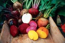 Legumes frescos cortados e inteiros em um caixote de madeira