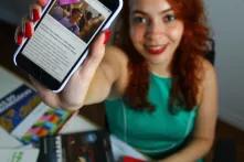 Jovem com celular na mão anunciando conteúdos da Fundação 