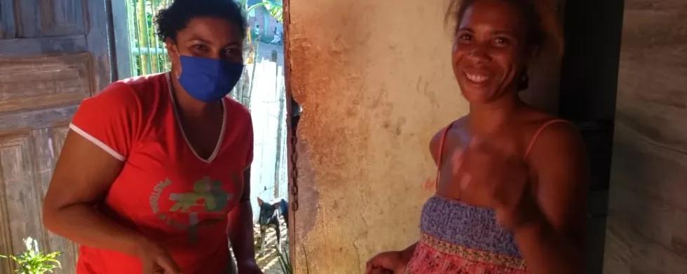 Mulheres negras entregando alimentos uma a outra