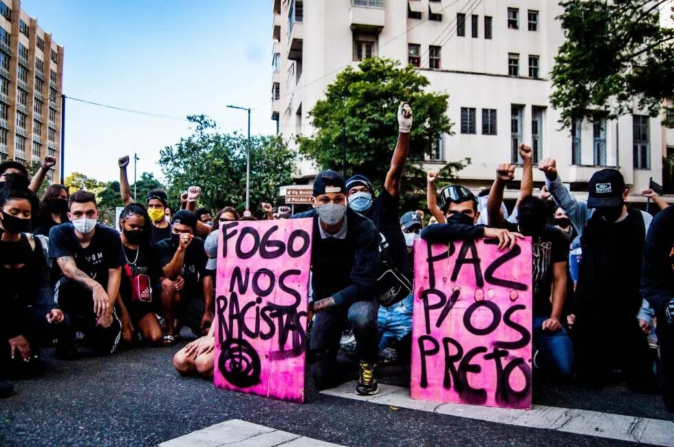 Manifestantes com cartazes contra o racismo estrutural