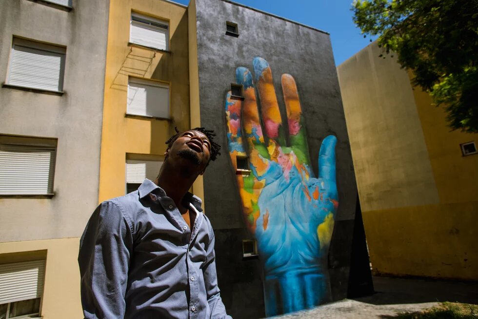 jovem olhando para o céu com arte do mapa mundi desenhada em forma de mão atrás