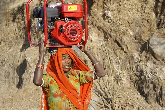 As mulheres das aldeiras de montanha em Rajasthan, Índia, transportam 32kg de madeira em suas cabeças para cozinhas todos os dias. Essa mulher está carregando um gerador para reparo em uma vila próxima. As mulheres das aldeiras de montanha em Rajasthan, Índia, transportam 32kg de madeira em suas cabeças para cozinhas todos os dias. Essa mulher está carregando um gerador para reparo em uma vila próxima.